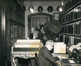 Fotografie Vlastimila Blažka při práci v archivu Pražské konzervatoře (F 7320)